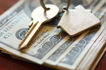 stack of one hundred dollar bills with house keys 