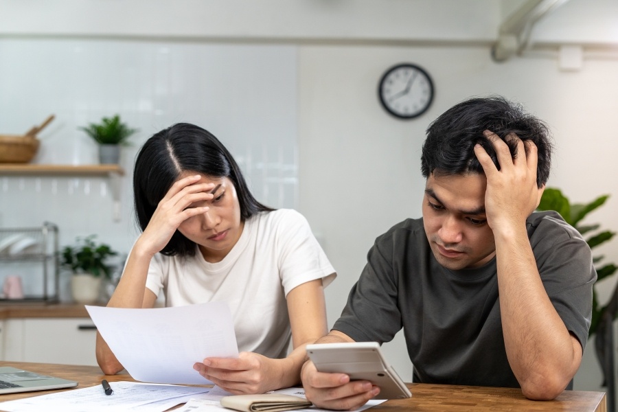 Smiling people at home reviewing bad credit loan offers on a laptop.